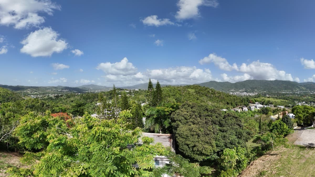 Interactive 360° aerial panorama over a hilltop residential neighborhood in the green mountains of Puerto Rico